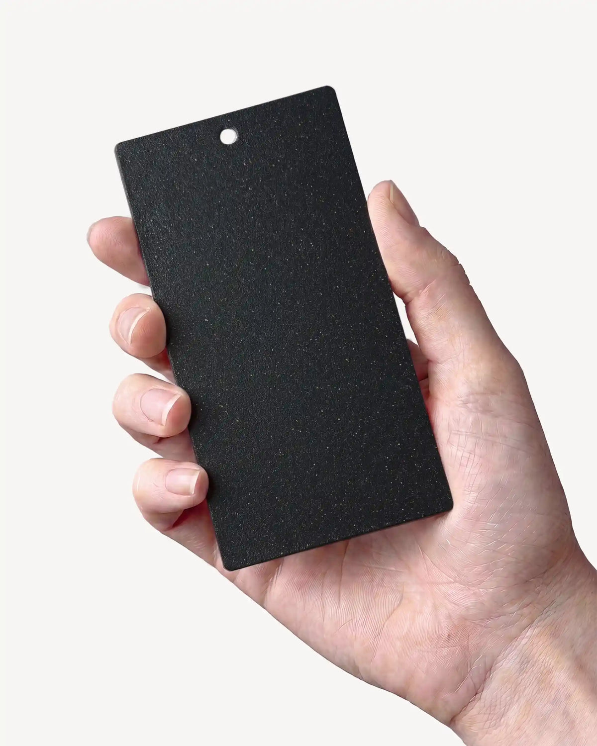 Hand holding a Deep Black PILOTIS color sample