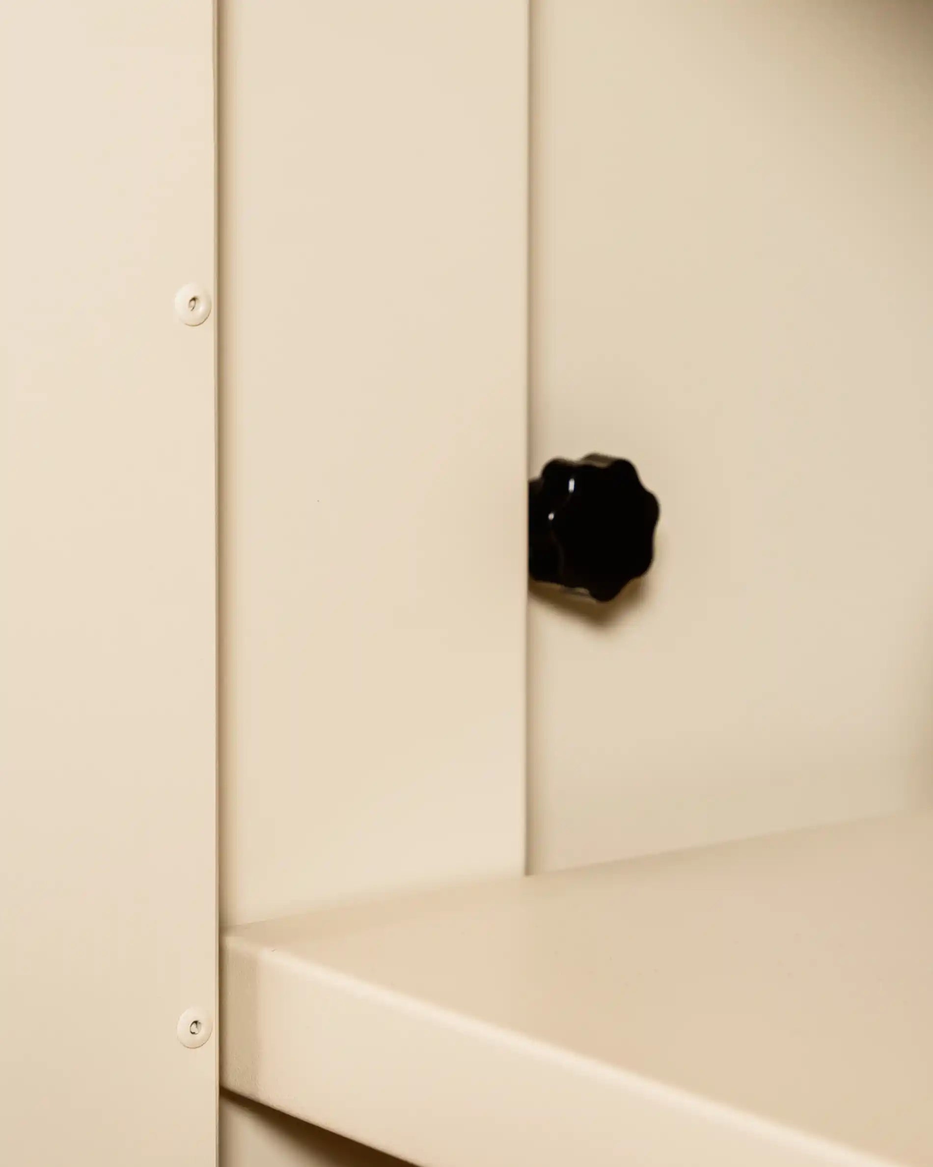Cream beige PILOTIS adjustment knob mounted on furniture corner