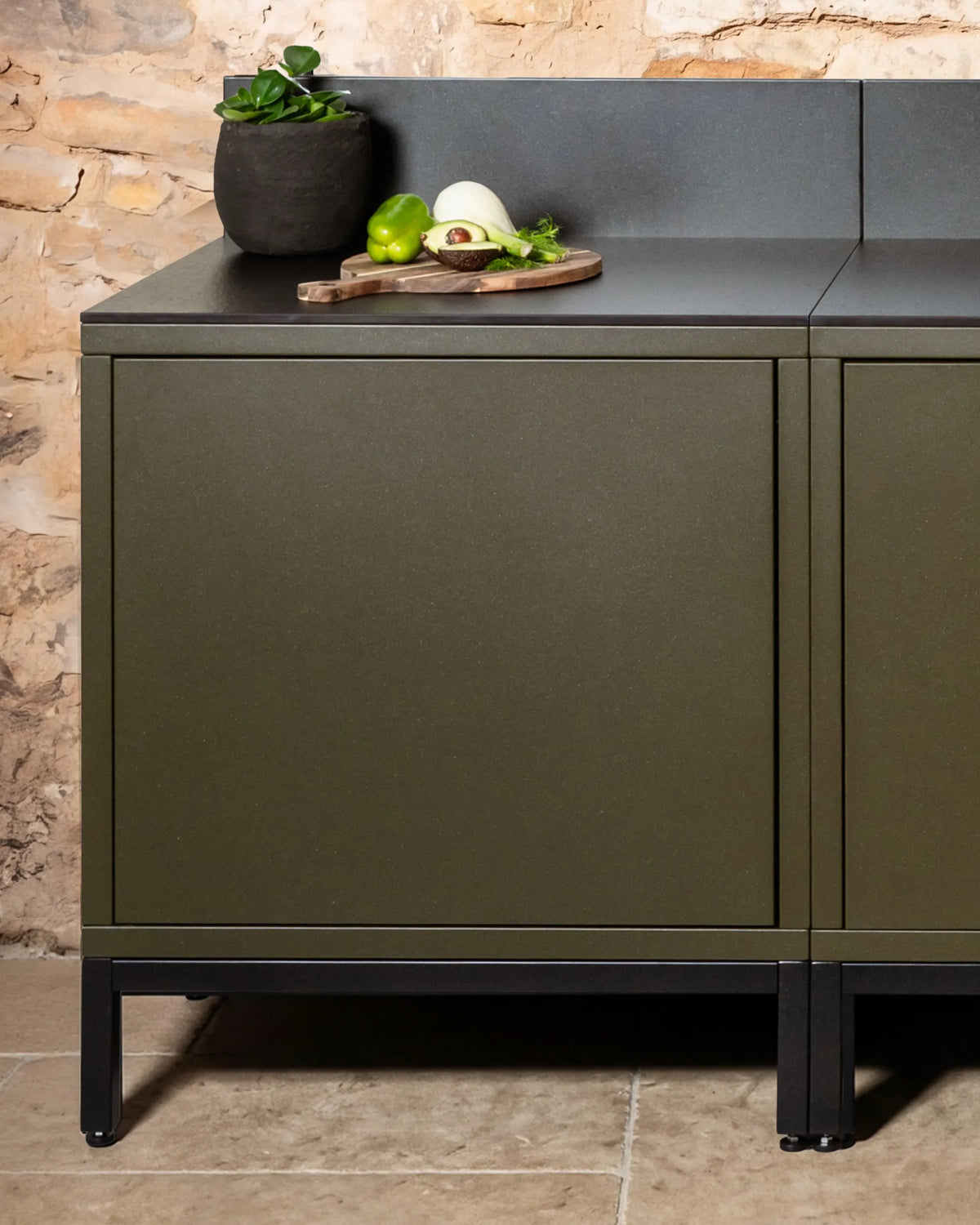 Black PILOTIS base structure with olive green cabinets, outdoor kitchen with black countertop