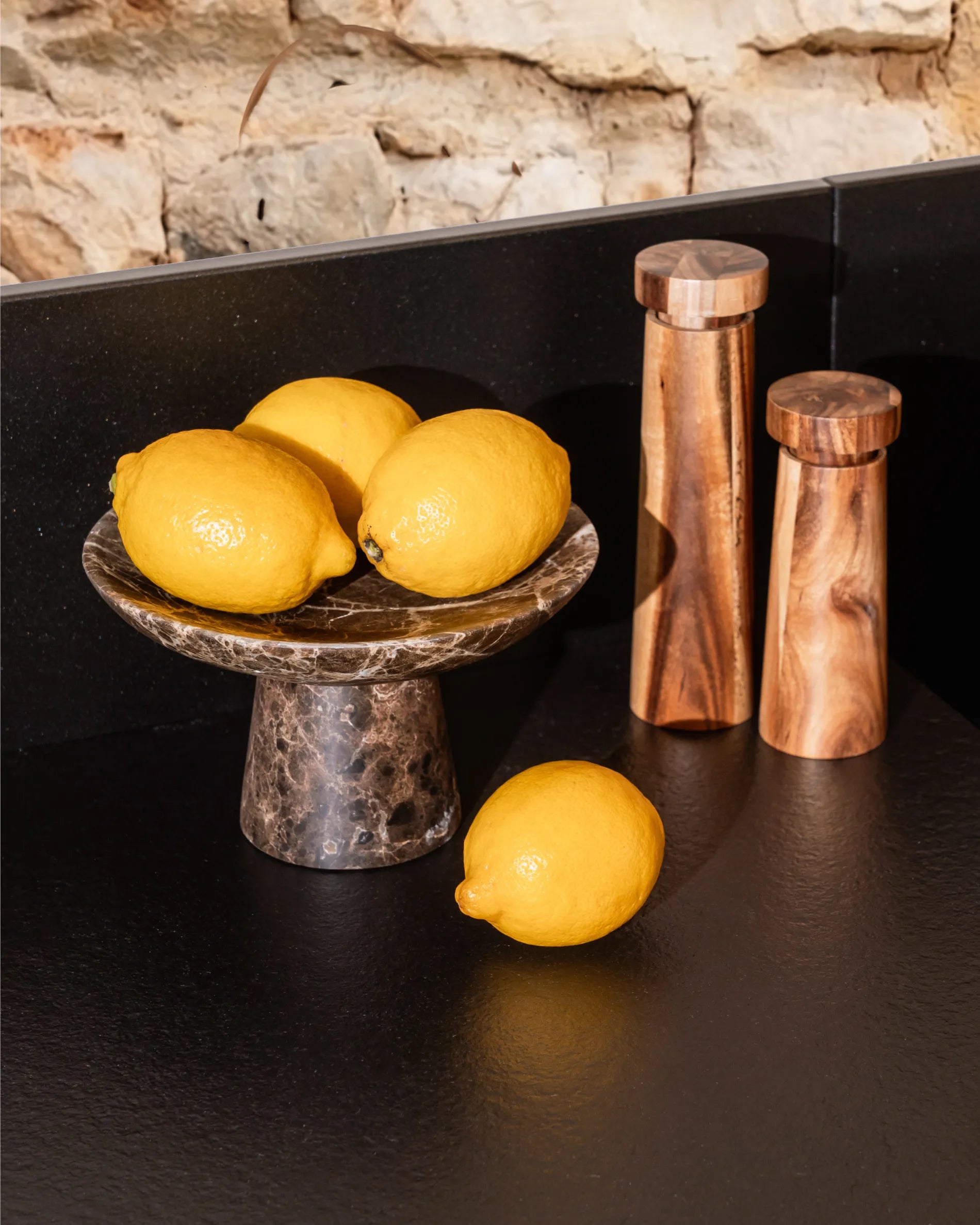 Black tray Classic PILOTIS module with lemons and copper spice mills, close-up