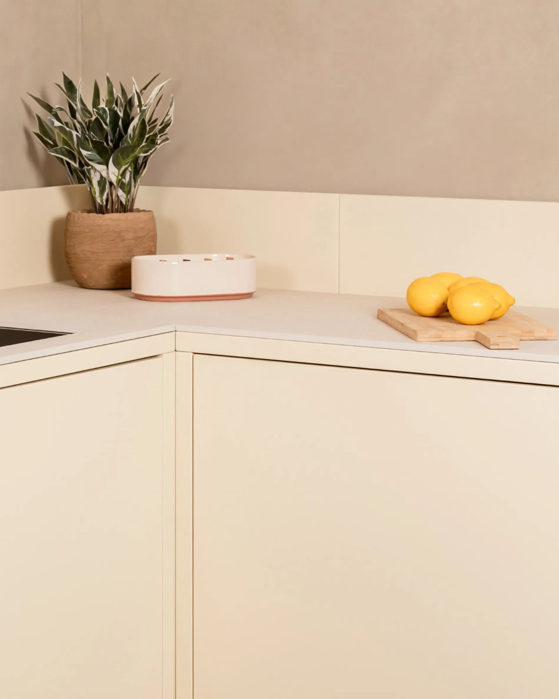 Cream beige PILOTIS corner unit for outdoor kitchens, with plant and lemons on the board