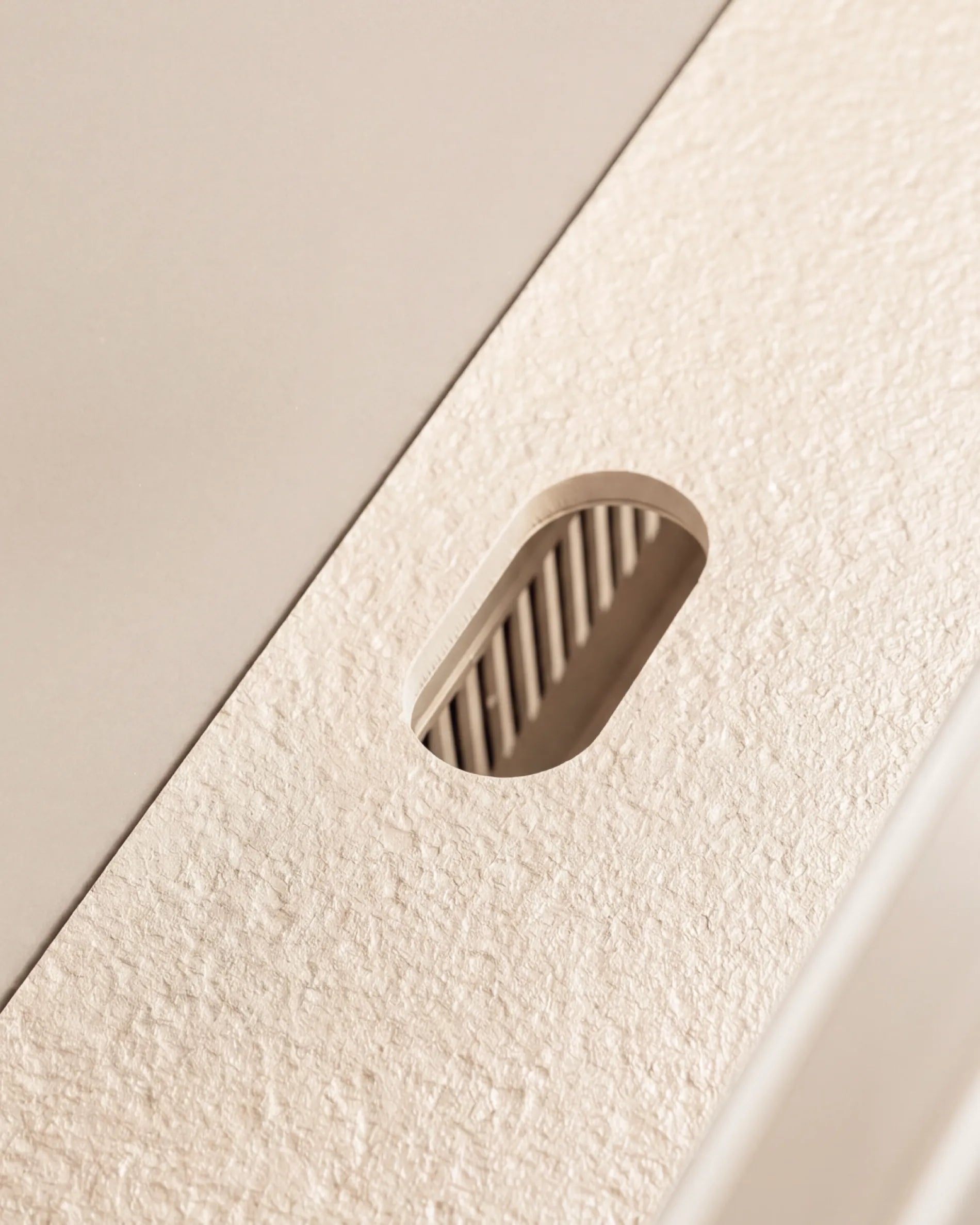 Oval cut-out of the cream beige Plancha PILOTIS module tray, close-up of the granulated texture