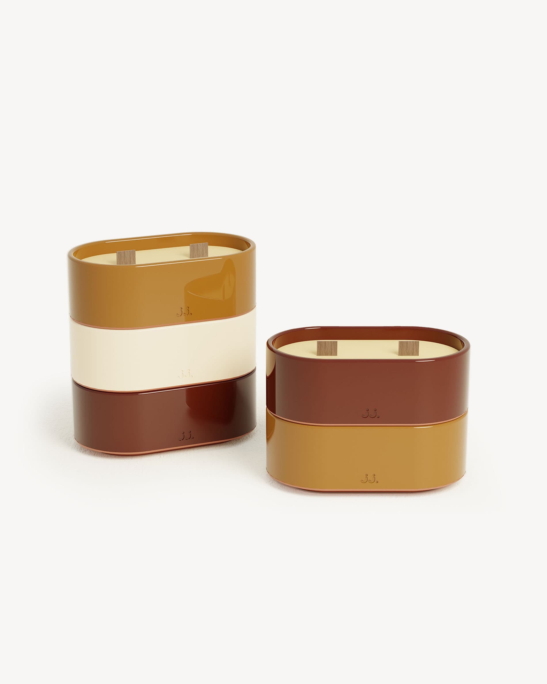 Totem S candles with red oxide and burnt sienna finishes, scented with citronella and notes of geranium and orange blossom.