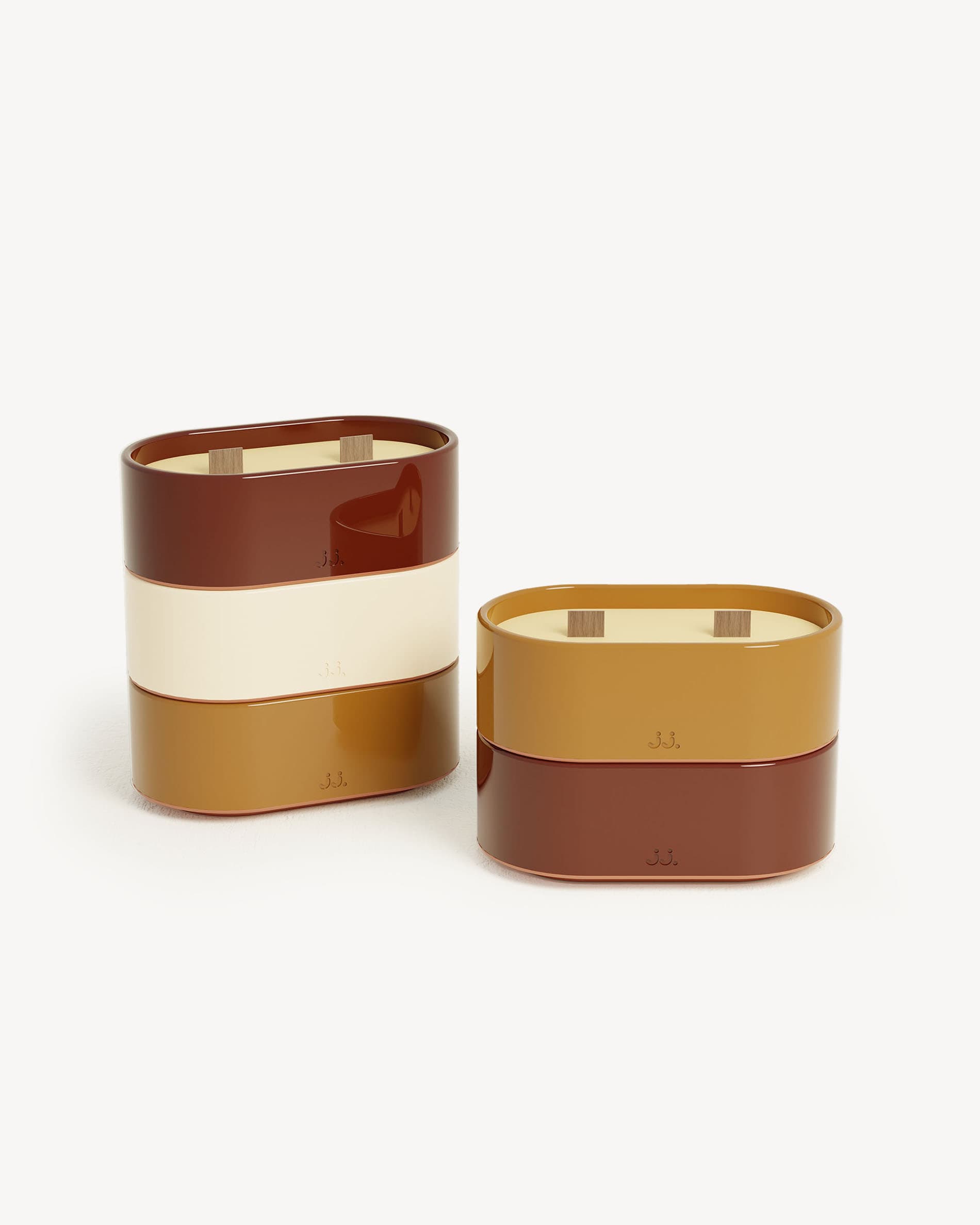 Totem S candles with red oxide and burnt sienna finishes, scented with citronella and notes of geranium and orange blossom.