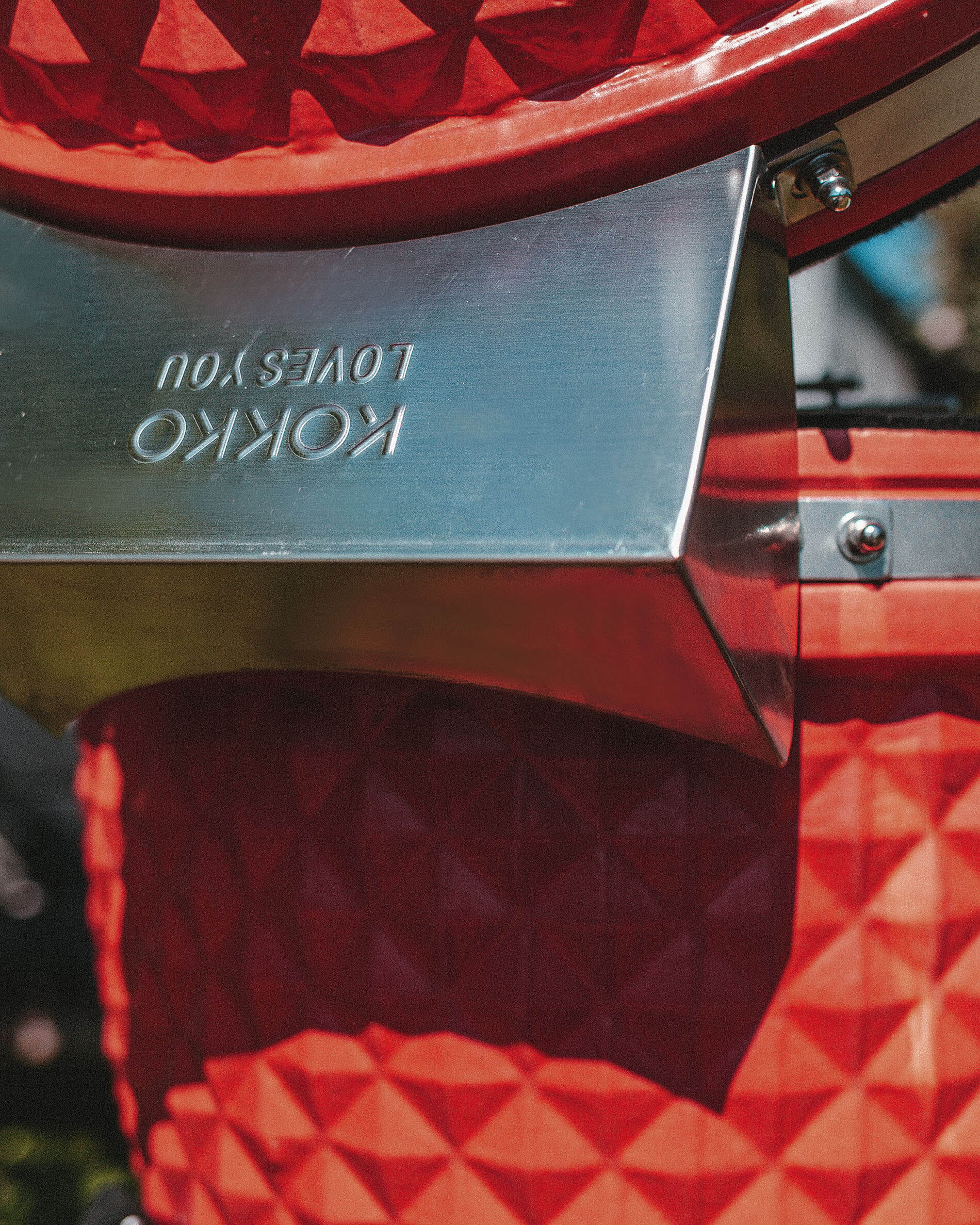 Stainless steel cover mounted on the rear hinge of the Kokko kamado.