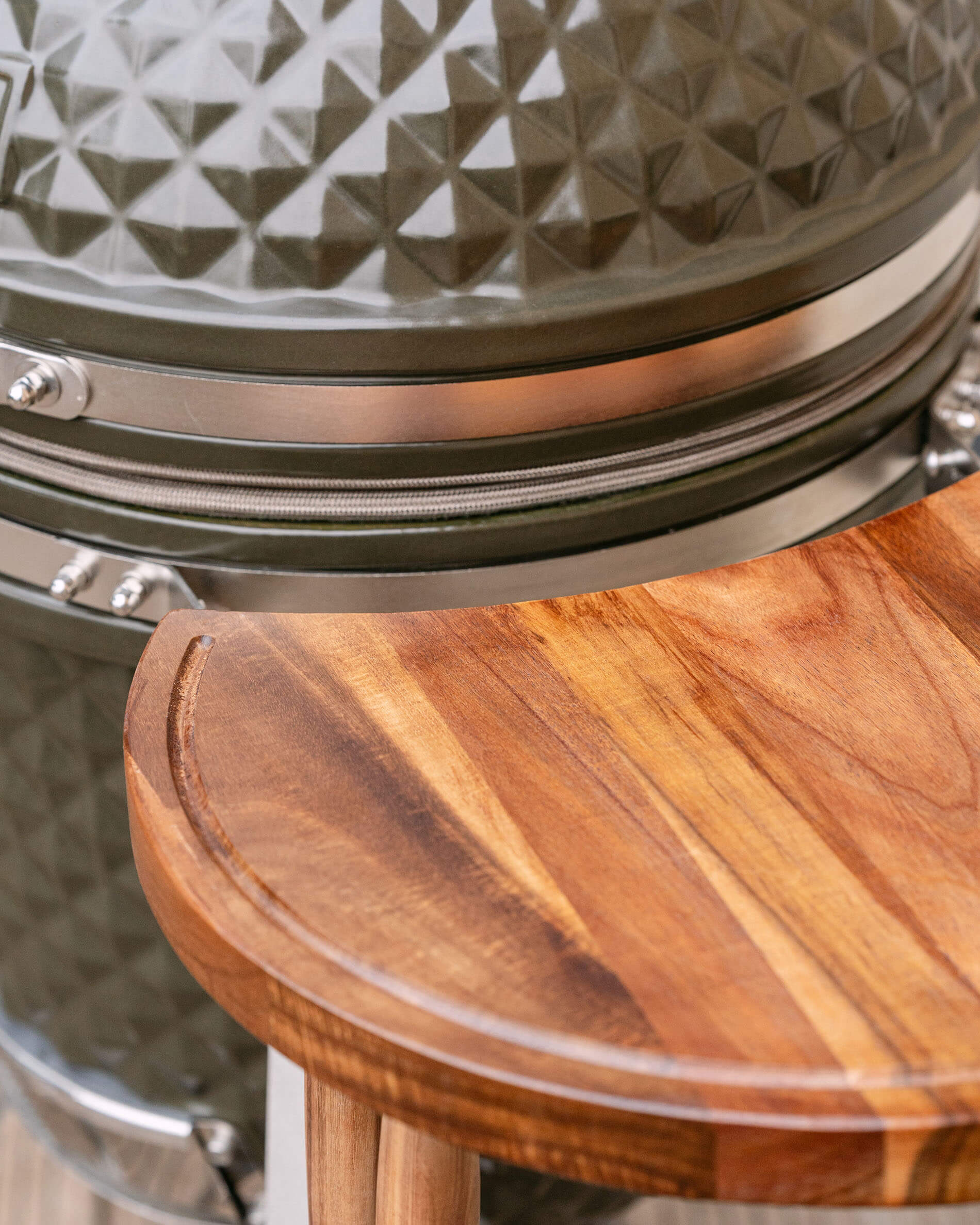 Close-up of the wooden side shelf on the Kokko kamado, highlighting the wood grain and seamless integration with the cart.