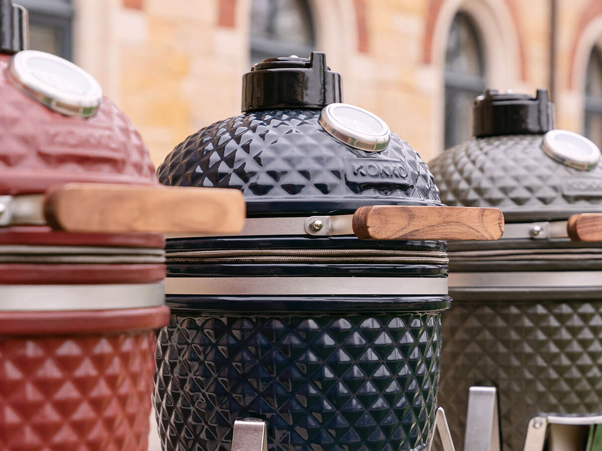 Three Kokko kamados in a row, in red, dark blue, and olive green ceramic.