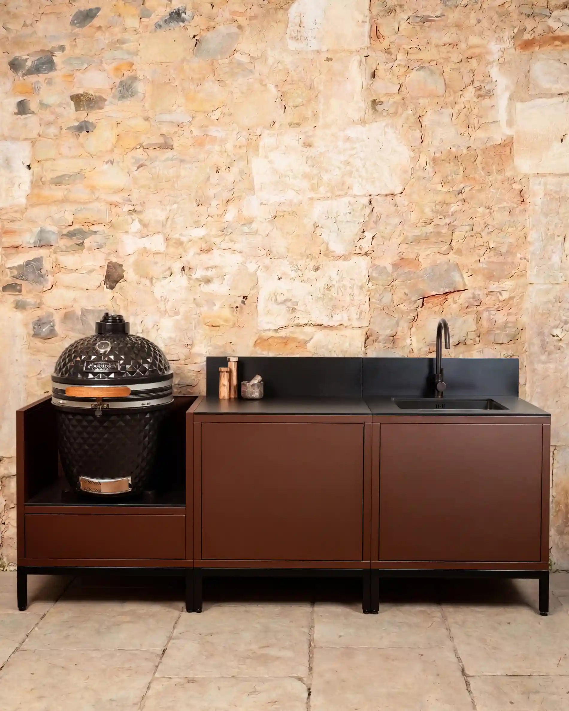 Kokko Pilotis rust outdoor kitchen with black worktop and kamado