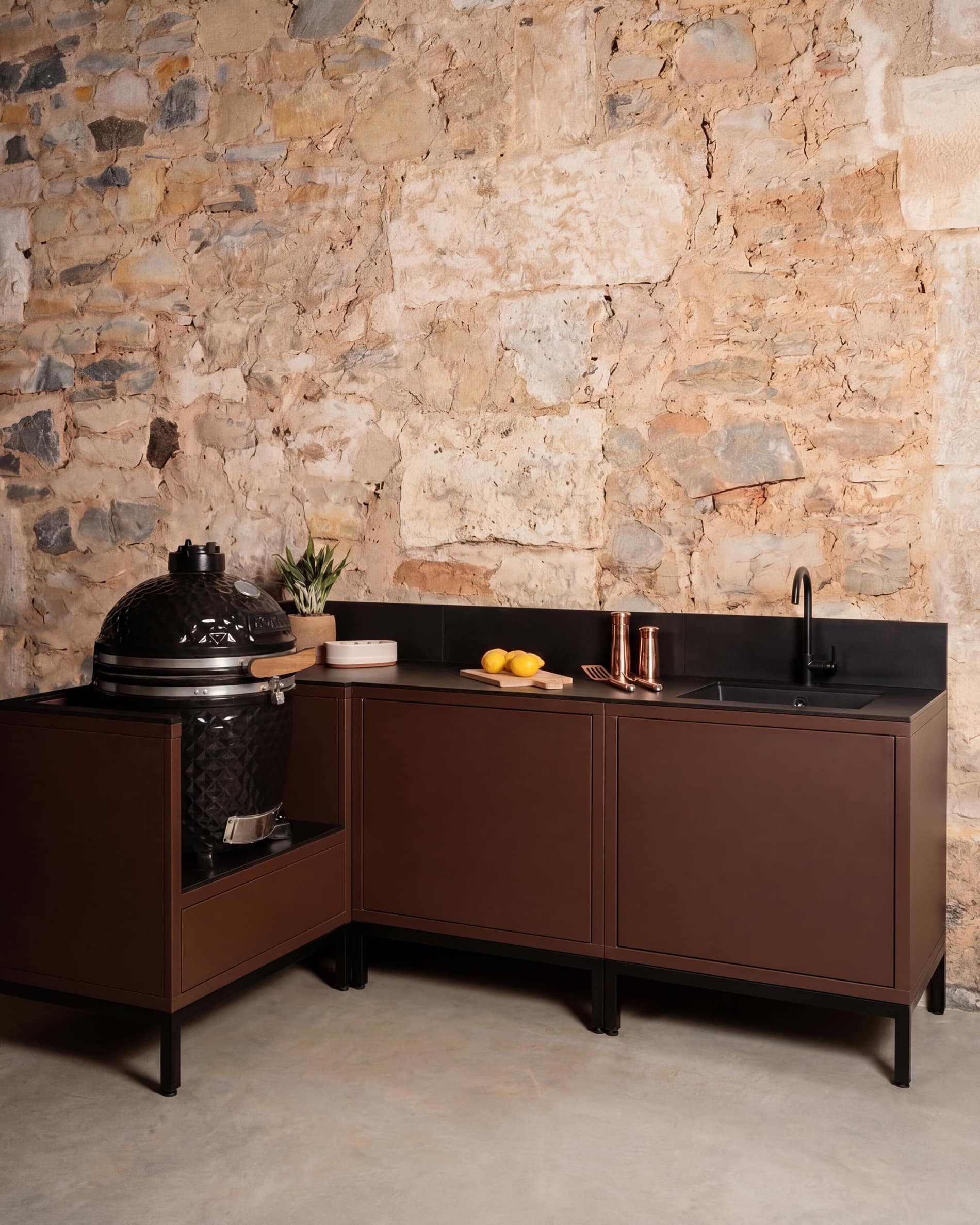 Kokko Pilotis corner outdoor kitchen in rust color with sink and built-in kamado