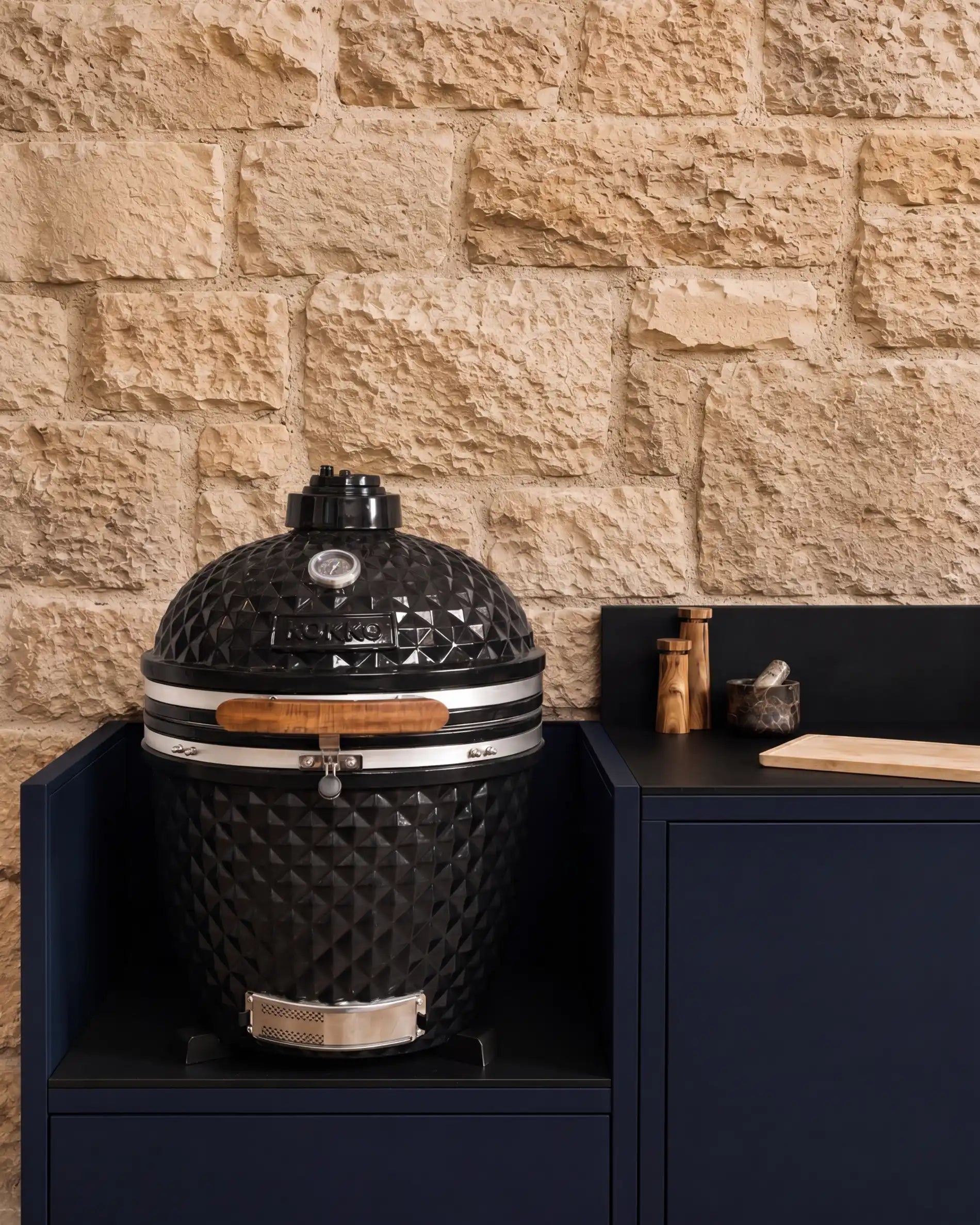 Gros plan kamado noir KOKKO sur module PILOTIS bleu marine