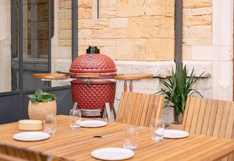 Kokko kamado cooking area with grill and accessories in use.
