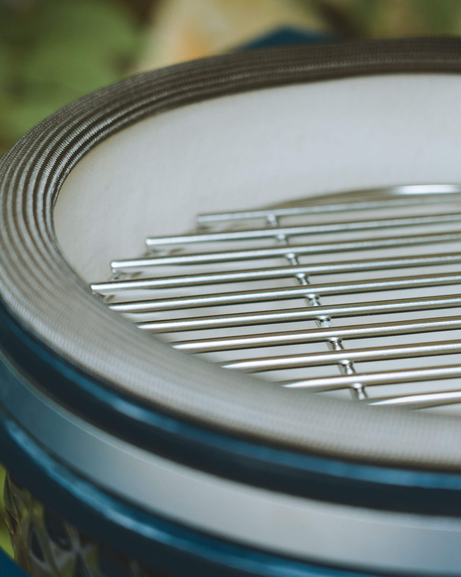 Gros plan sur la grille de cuisson en inox et le joint du couvercle d’un kamado Kokko coloris océan.