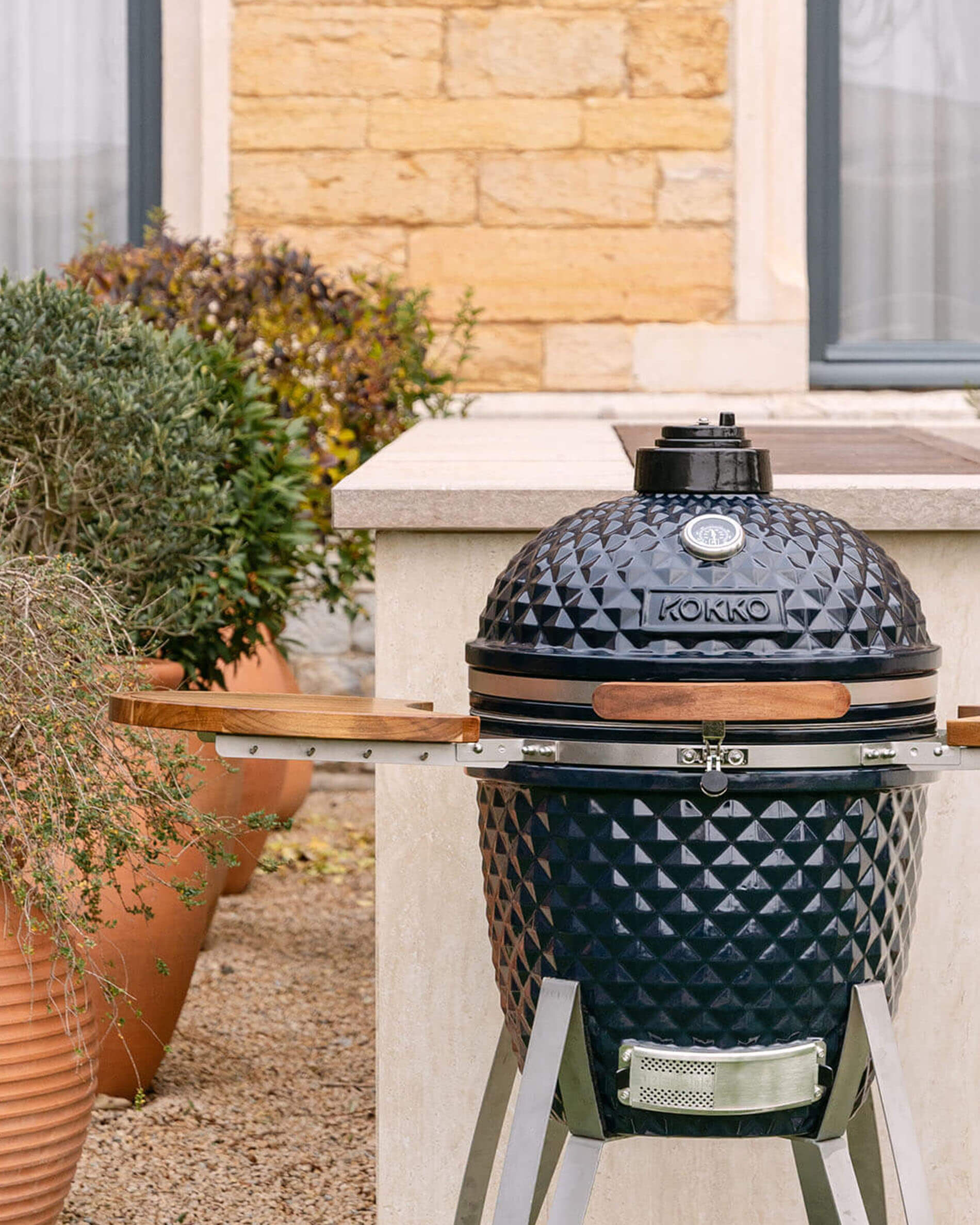 Kokko 22-inch navy kamado barbecue, shown alone outdoors.