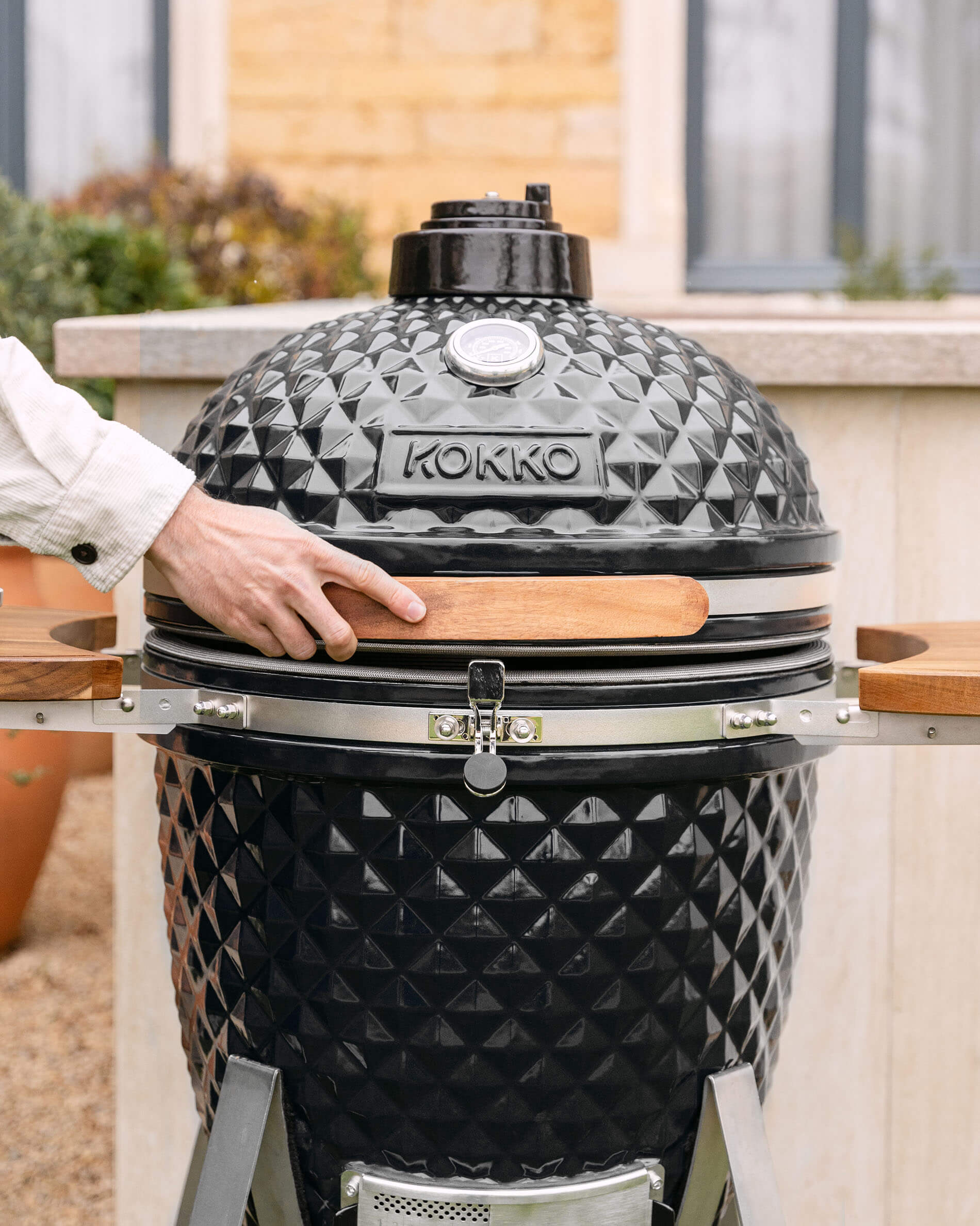 Kokko XL 22-inch ceramic kamado in black, set up outdoors.