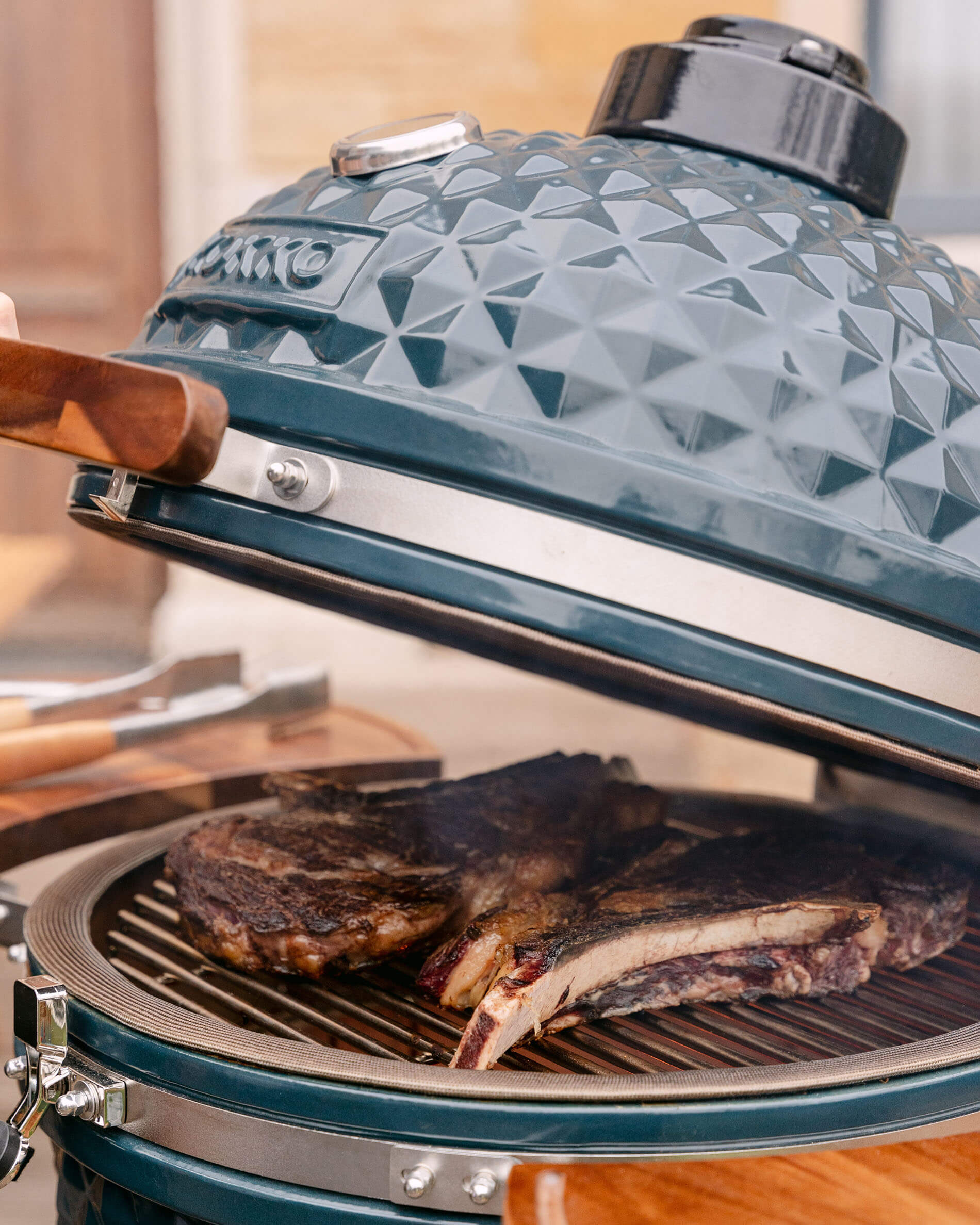 Detail of the lid on a Kokko XL 22-inch ocean blue ceramic kamado.