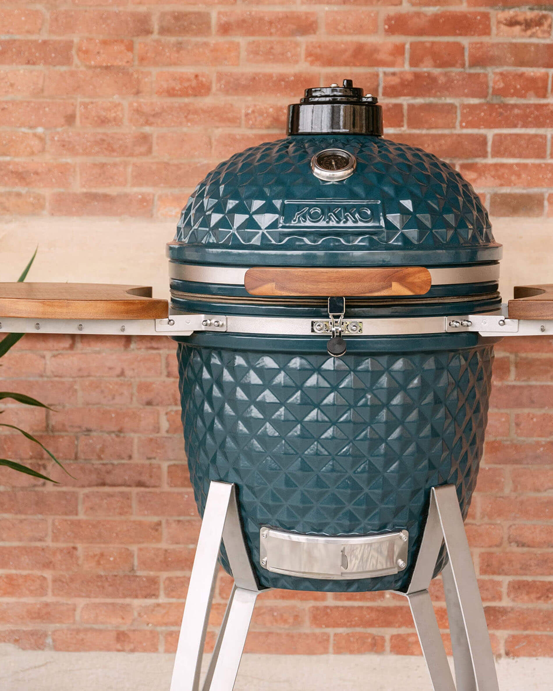 Kokko 22-inch ocean blue kamado barbecue, shown alone outdoors.