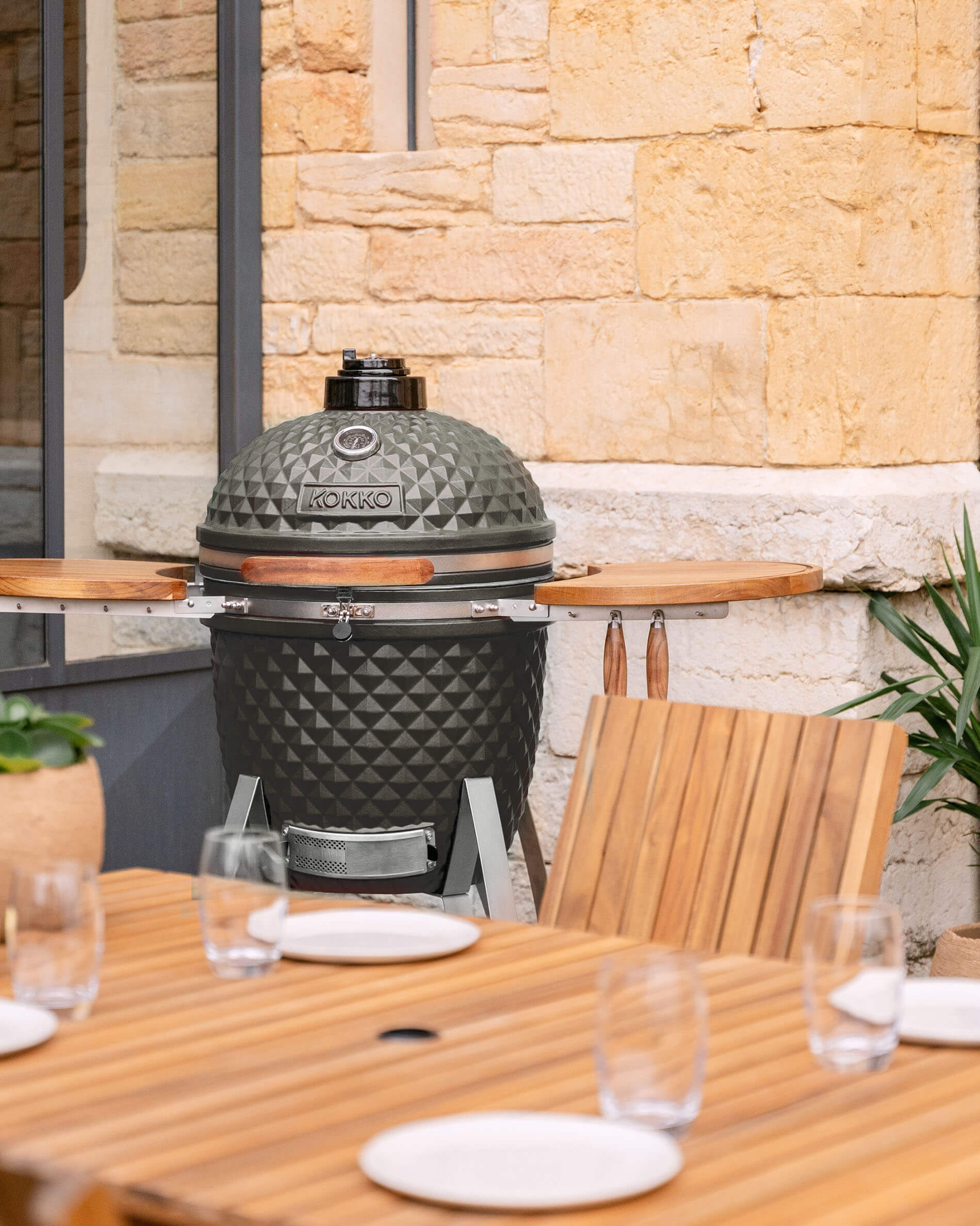 Olive green Kokko 22-inch ceramic kamado displayed on a terrace.
