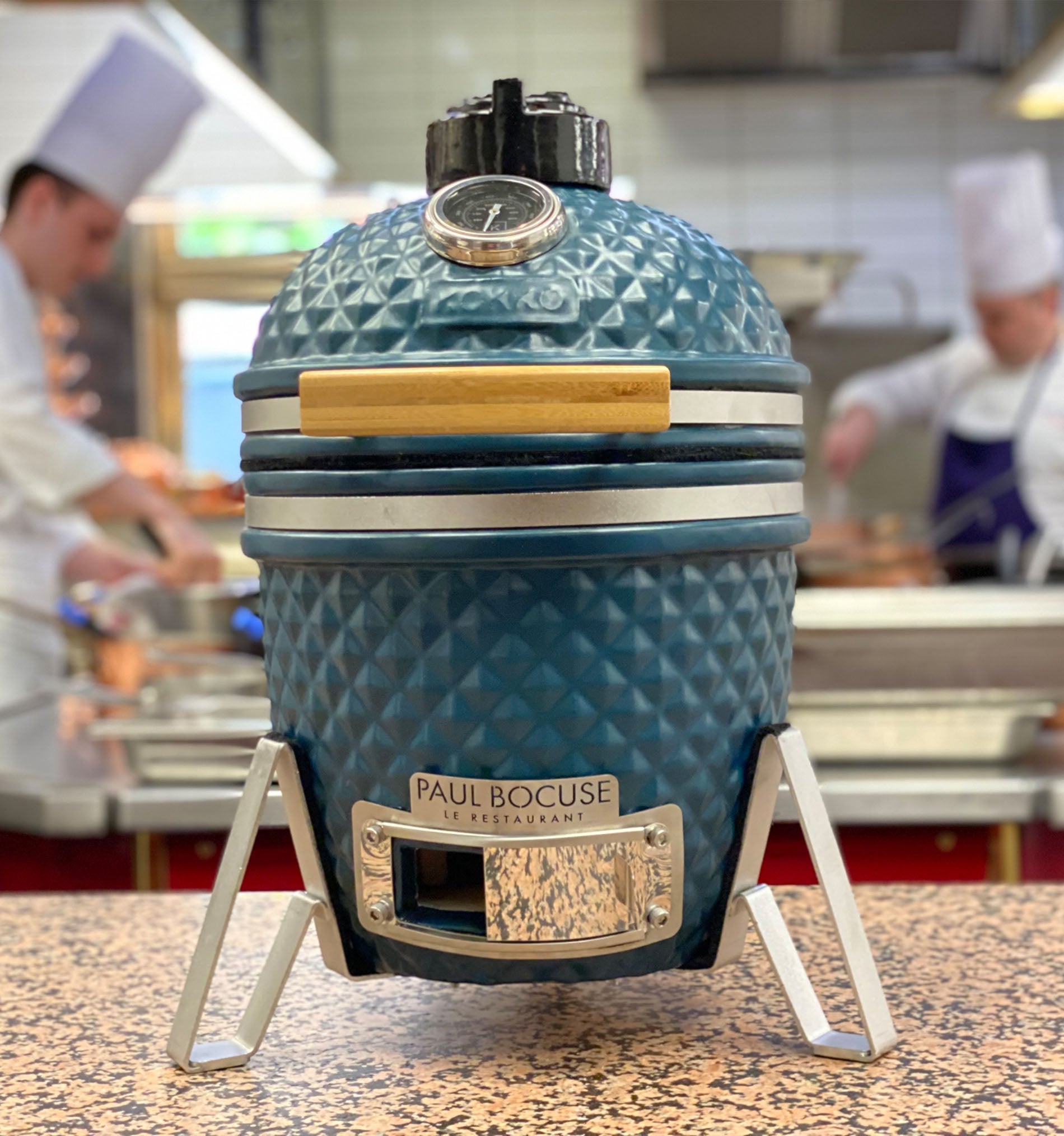 Ocean blue Kokko kamado set up in front of a Paul Bocuse fine dining restaurant.