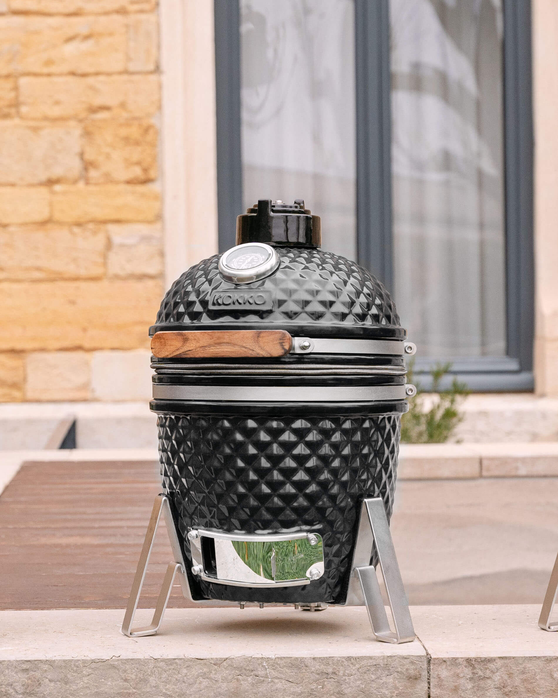 Little Kokko 13 ceramic kamado in deep black on its stand.