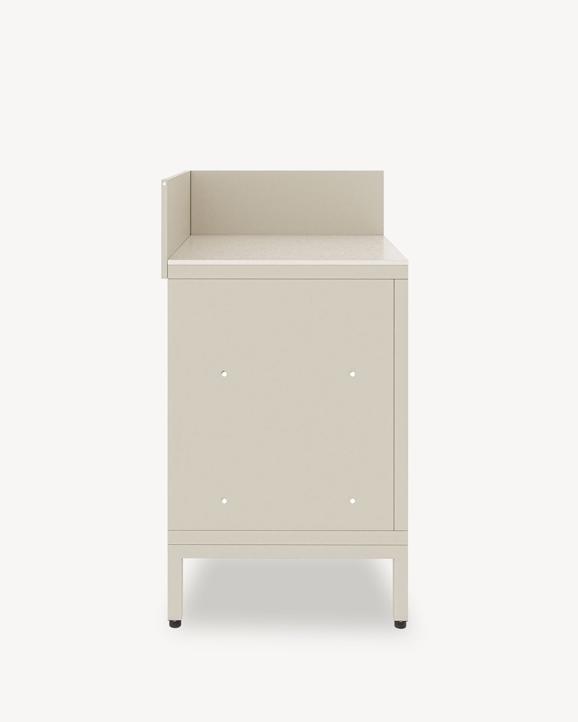 Module de cuisine pilotis d’angle, meuble coloris crème avec rangement fermé, plan de travail sombre et crédence latérale intégrée.