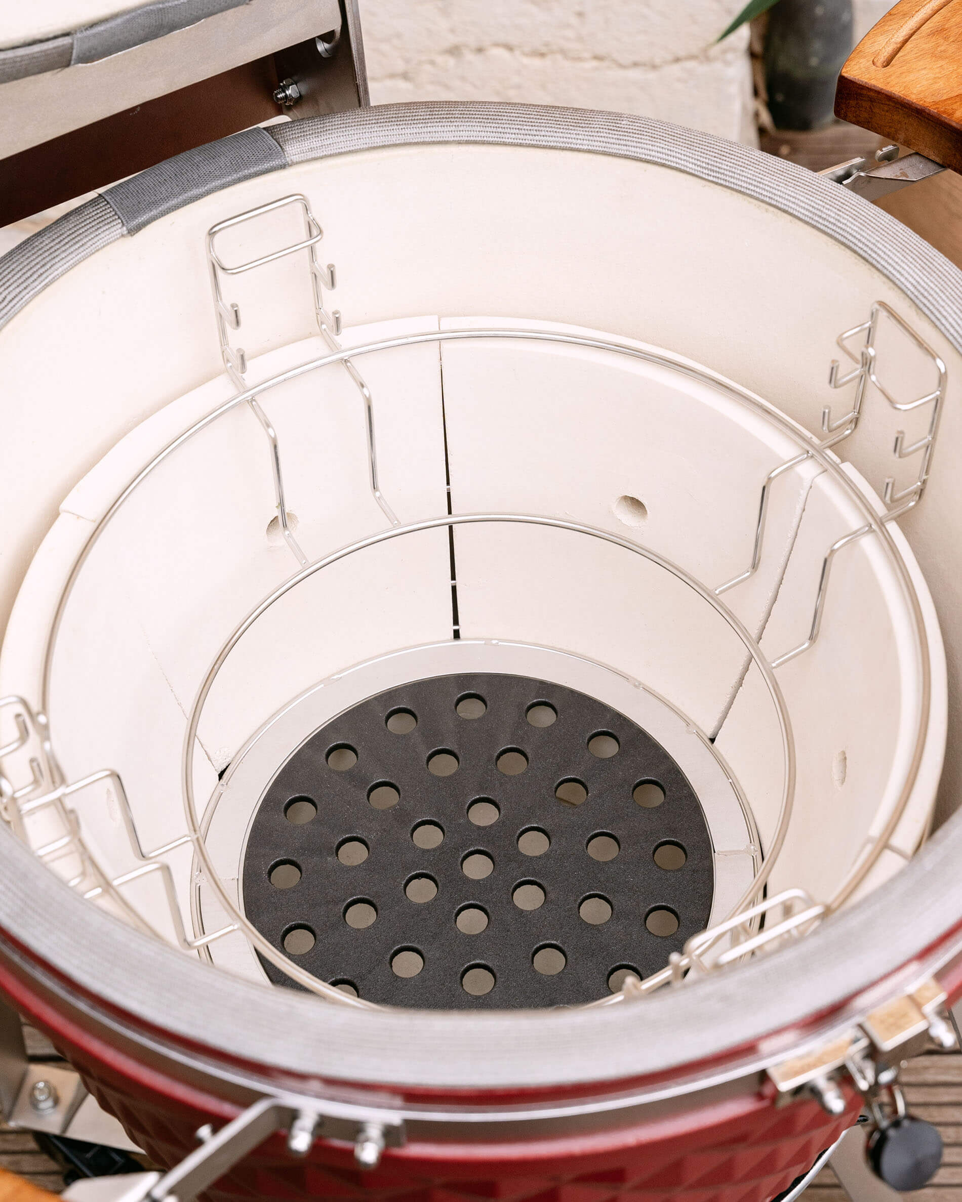 Perforated cast iron plate for optimal airflow and charcoal circulation in the kamado.