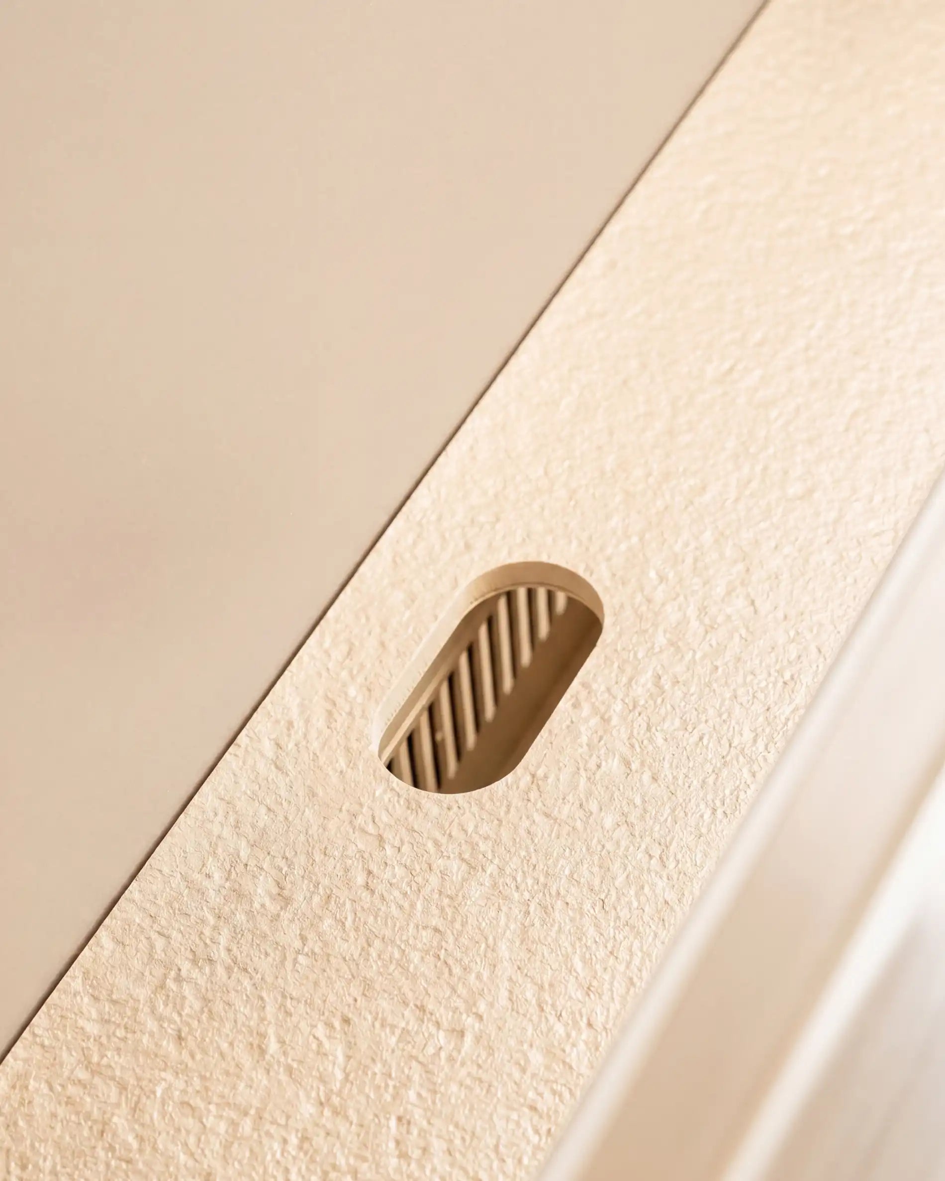 Cable pass-through detail on worktop of Kokko cream outdoor kitchen